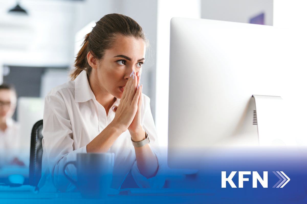 Professional business woman holds hands over face in stress over computer issues